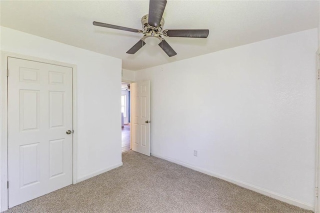 6021 E 151st Ter, Grandview, MO 64030 - unfurnished bedroom featuring light colored carpet, baseboards, and a ceiling fan