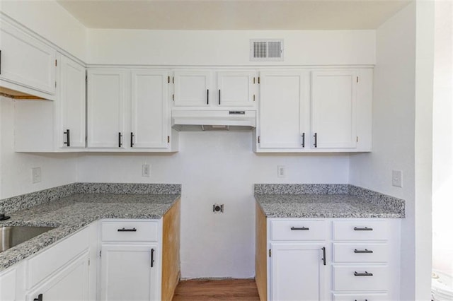 6021 E 151st Ter, Grandview, MO 64030 - kitchen featuring under cabinet range hood, white cabinets, and light stone counters