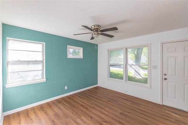 6021 E 151st Ter, Grandview, MO 64030 - unfurnished room with wood finished floors, a ceiling fan, and baseboards