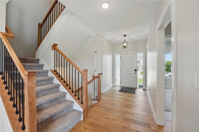 entrance foyer with light wood-type flooring, baseboards, stairs, recessed lighting, and a chandelier