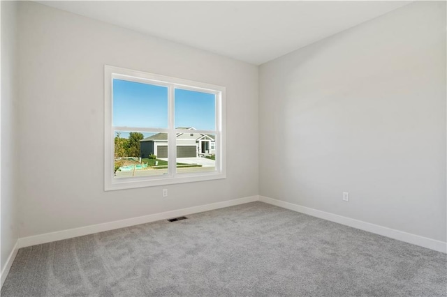 empty room featuring carpet floors and baseboards