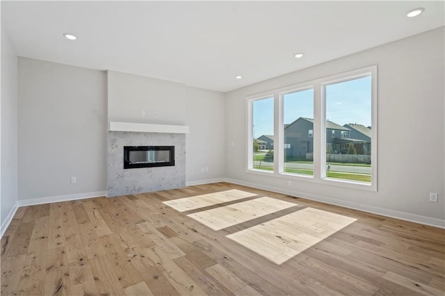 unfurnished living room featuring light wood-style floors, baseboards, and recessed lighting
