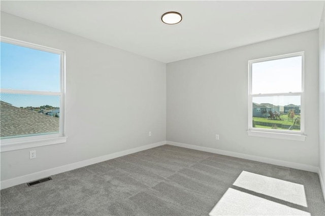 carpeted spare room featuring baseboards