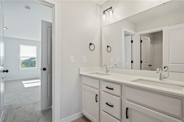 full bath featuring double vanity and baseboards