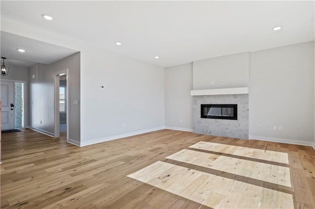 unfurnished living room featuring wood finished floors, baseboards, and recessed lighting
