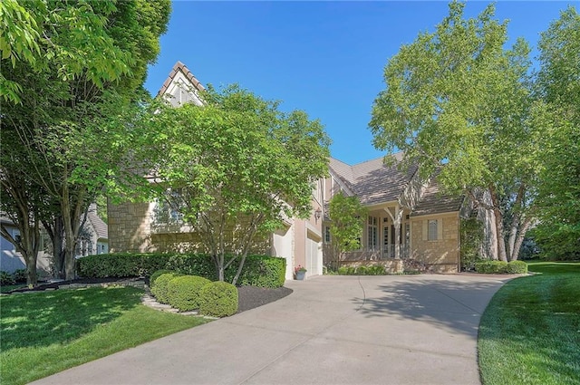 11352 El Monte Ct, Leawood, KS 66211 - view of property hidden behind natural elements featuring a front lawn and concrete driveway