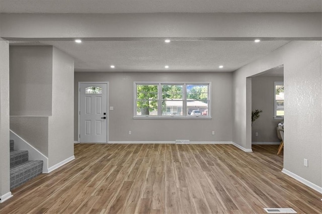 entrance foyer with wood finished floors, recessed lighting, baseboards, and stairs