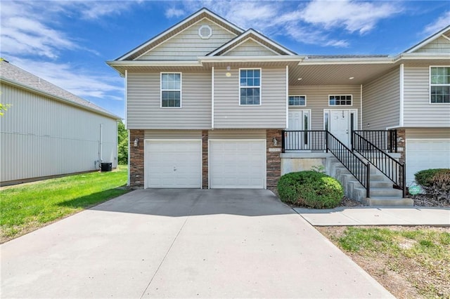 view of front of home featuring an attached garage, concrete driveway, and central AC