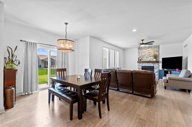 19623 W 196th Ter, Spring Hill, KS 66083 - dining space featuring light wood-style flooring, ceiling fan, a stone fireplace, a chandelier, and recessed lighting