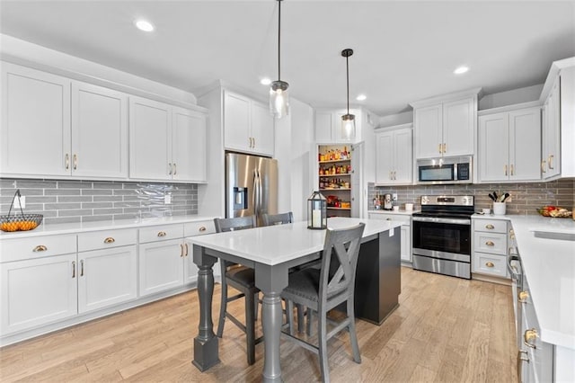 19623 W 196th Ter, Spring Hill, KS 66083 - kitchen with stainless steel appliances, light countertops, decorative backsplash, white cabinetry, and light wood-type flooring