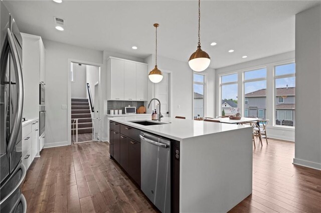 15932 W 171st Ter, Olathe, KS 66062 - kitchen with stainless steel appliances, a sink, light countertops, white cabinets, and dark wood-style floors