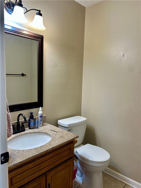 102 Willow Pt, Lansing, KS 66043 - half bathroom with vanity, tile patterned floors, toilet, and baseboards