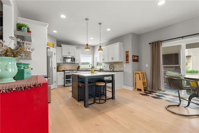 16966 S Durango St, Olathe, KS 66062 - kitchen with stainless steel appliances, a breakfast bar, light wood-style flooring, white cabinetry, and recessed lighting