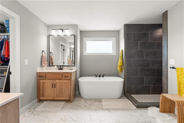 16966 S Durango St, Olathe, KS 66062 - bathroom with marble finish floors, vanity, a freestanding tub, a walk in shower, and baseboards