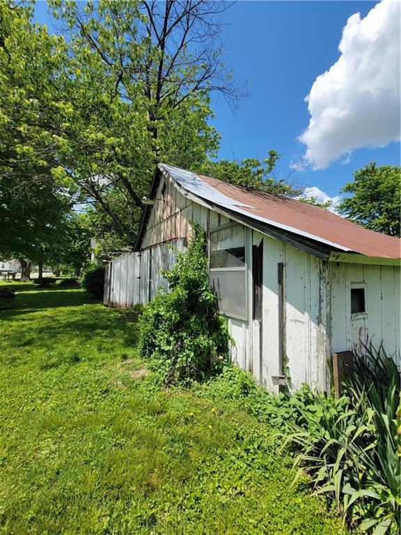 111 S Wall St, Leeton, MO 64761 - view of side of home featuring a lawn