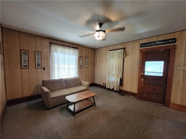 111 S Wall St, Leeton, MO 64761 - carpeted living room featuring ceiling fan, baseboards, and wooden walls