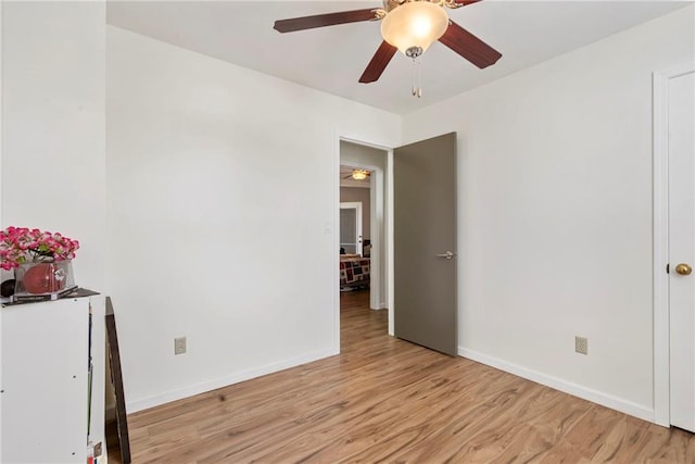 unfurnished bedroom featuring light wood-style floors, baseboards, and a ceiling fan