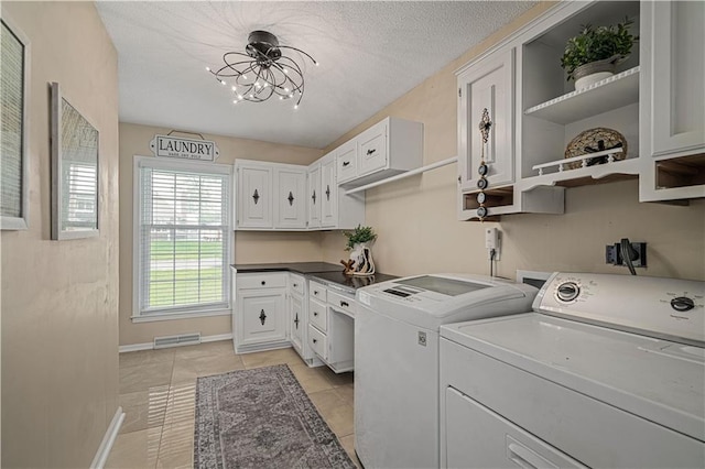 2532 N 73rd St, Kansas City, KS 66109 - laundry room with washer and dryer, a chandelier, cabinet space, light tile patterned flooring, and baseboards