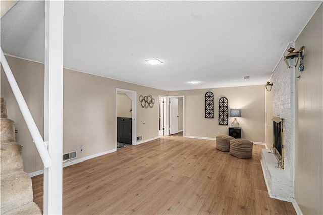 2532 N 73rd St, Kansas City, KS 66109 - living area featuring light wood-type flooring, stairway, baseboards, and a brick fireplace