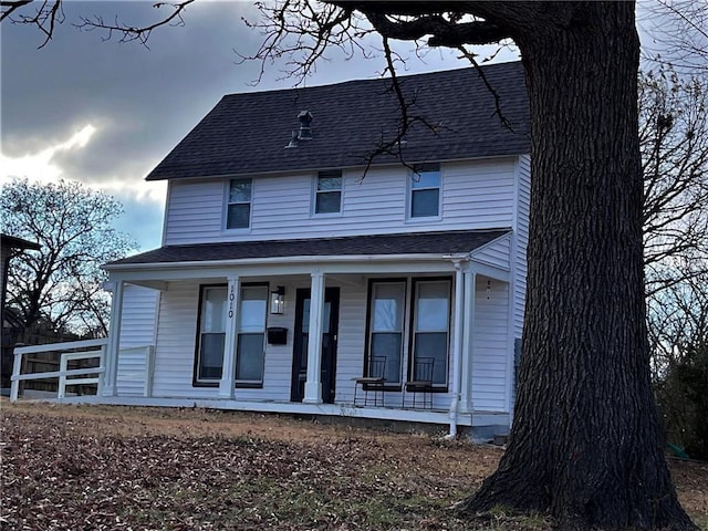 view of front of property with covered porch and roof with shingles