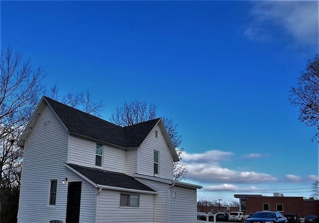 view of side of property with a shingled roof