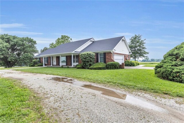 28210 Hedge Ln, Paola, KS 66071 - single story home featuring brick siding, driveway, a garage, and a front lawn