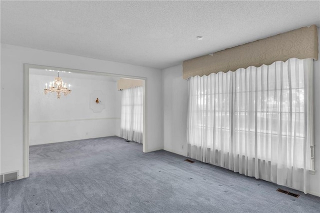 28210 Hedge Ln, Paola, KS 66071 - spare room with carpet flooring, a chandelier, and a textured ceiling