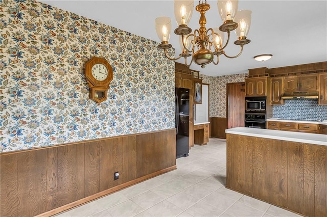 28210 Hedge Ln, Paola, KS 66071 - kitchen featuring black appliances, wallpapered walls, wainscoting, under cabinet range hood, and a chandelier