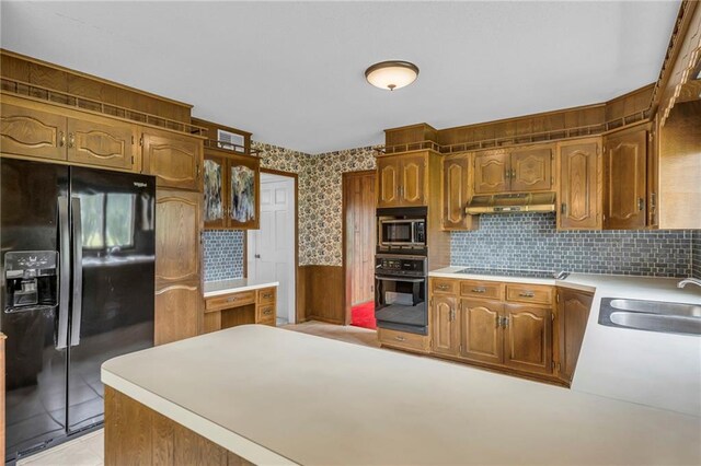 28210 Hedge Ln, Paola, KS 66071 - kitchen with black appliances, a sink, under cabinet range hood, light countertops, and wallpapered walls