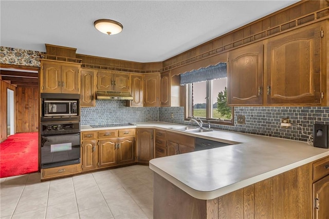 28210 Hedge Ln, Paola, KS 66071 - kitchen featuring black appliances, under cabinet range hood, a sink, a peninsula, and light countertops
