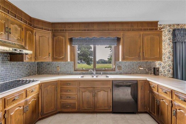 28210 Hedge Ln, Paola, KS 66071 - kitchen with black appliances, a sink, under cabinet range hood, light countertops, and decorative backsplash