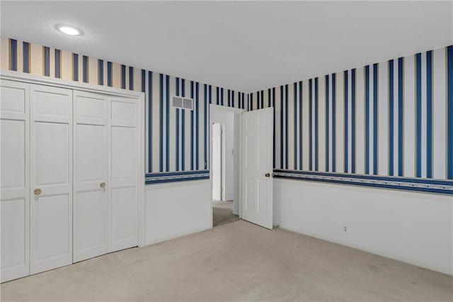 28210 Hedge Ln, Paola, KS 66071 - unfurnished bedroom with light carpet, wallpapered walls, and a closet