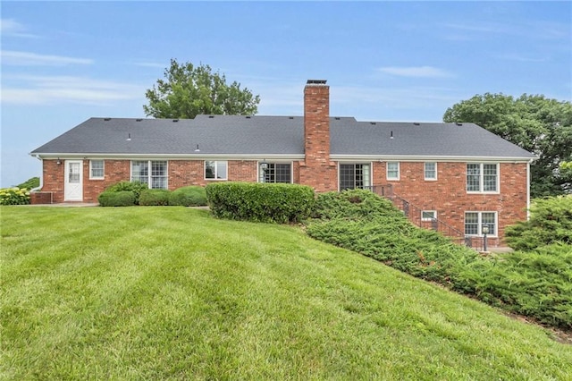 28210 Hedge Ln, Paola, KS 66071 - rear view of house featuring a chimney, a yard, brick siding, and central air condition unit