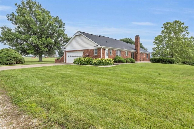 28210 Hedge Ln, Paola, KS 66071 - view of front of property with concrete driveway, a chimney, a front lawn, brick siding, and a garage