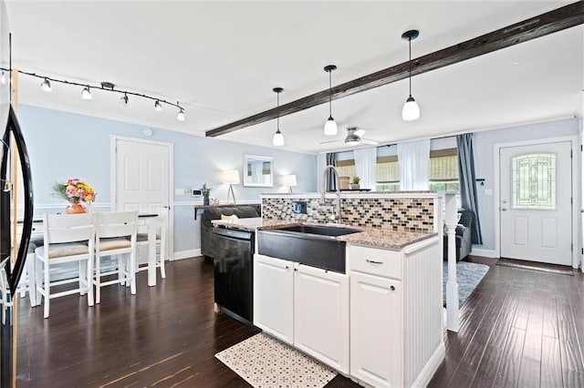 kitchen featuring black appliances, a sink, beamed ceiling, a ceiling fan, and decorative light fixtures