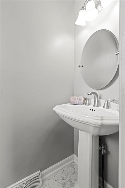 bathroom with baseboards and marble finish floors