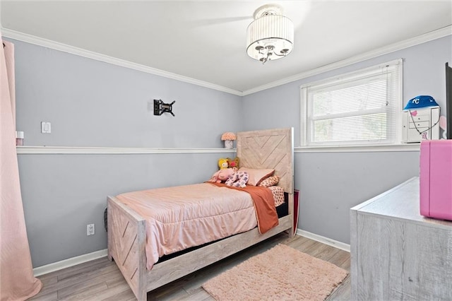 bedroom with wood finished floors, ornamental molding, and baseboards