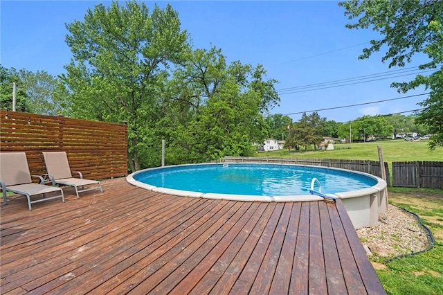 view of pool with a wooden deck and fence