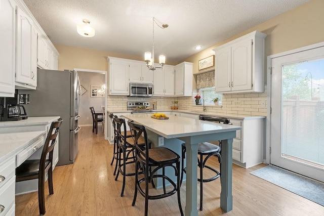 14263 W 129th Ter, Olathe, KS 66062 - kitchen with appliances with stainless steel finishes, a sink, white cabinetry, and backsplash