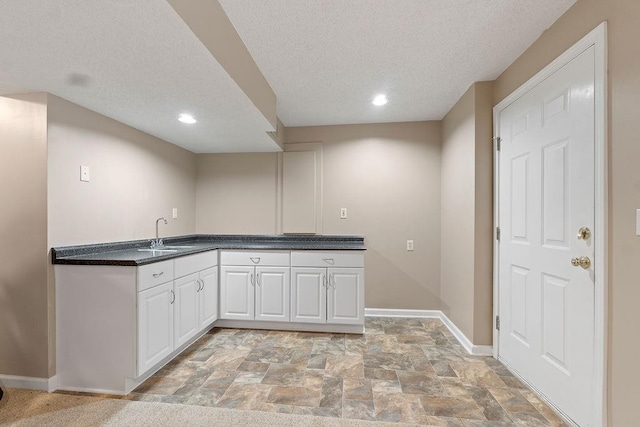 14263 W 129th Ter, Olathe, KS 66062 - kitchen with baseboards, white cabinets, light stone finish floors, a textured ceiling, and a sink