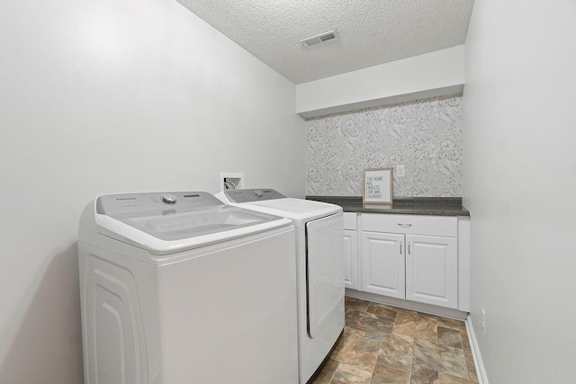 14263 W 129th Ter, Olathe, KS 66062 - laundry area with washing machine and dryer, stone finish flooring, cabinet space, a textured ceiling, and baseboards