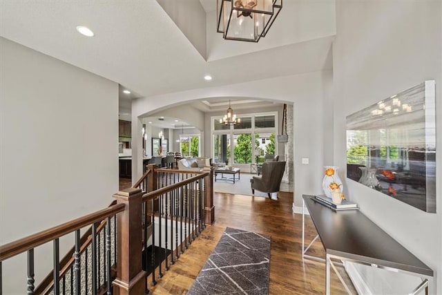 16456 Cody St, Overland Park, KS 66062 - hall featuring a chandelier, arched walkways, wood finished floors, an upstairs landing, and recessed lighting
