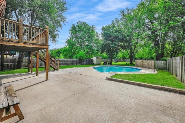 view of swimming pool featuring a storage unit, a patio, stairway, an outdoor structure, and a deck