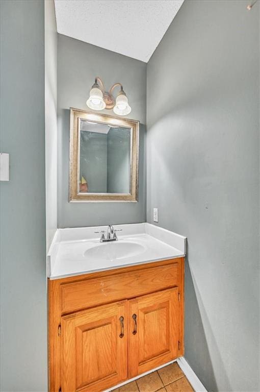 bathroom with tile patterned flooring, vanity, and baseboards