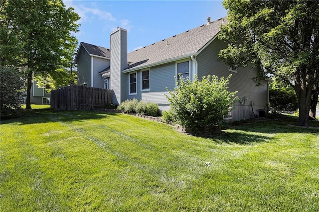 7001 W 157th Ter, Overland Park, KS 66223 - back of house featuring a chimney, a shingled roof, and central AC unit