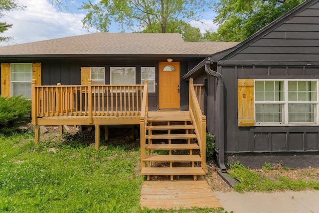 14213 S Haven Rd, Grandview, MO 64030 - view of front of house featuring board and batten siding, a shingled roof, and a wooden deck