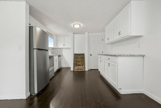 14213 S Haven Rd, Grandview, MO 64030 - kitchen with appliances with stainless steel finishes, dark wood-style flooring, baseboards, and white cabinets