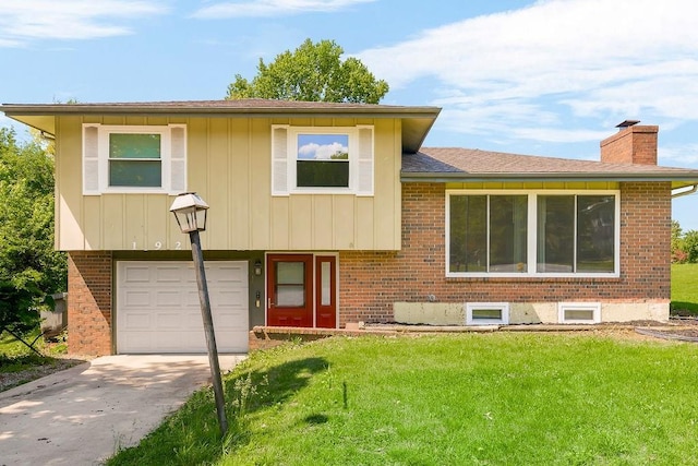 1924 N 75th Dr, Kansas City, KS 66112 - tri-level home with an attached garage, a front yard, brick siding, and a chimney