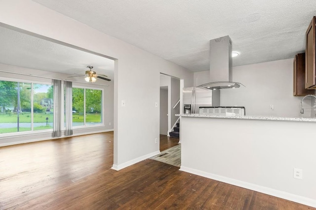 1924 N 75th Dr, Kansas City, KS 66112 - kitchen with island exhaust hood, dark wood-type flooring, a peninsula, baseboards, and a ceiling fan