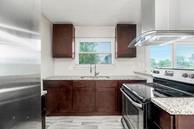 1924 N 75th Dr, Kansas City, KS 66112 - kitchen with stainless steel electric range oven, exhaust hood, a sink, a textured ceiling, and dark brown cabinetry